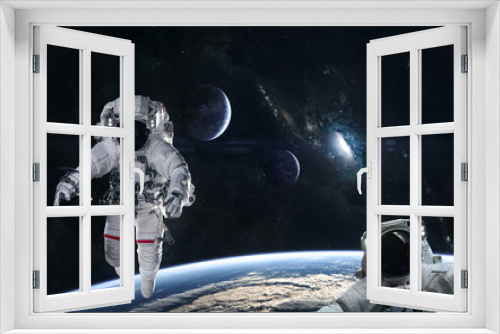 Fototapeta Naklejka Na Ścianę Okno 3D - Astronauts in orbit of the planet on a background of blue spiral galaxy somewhere in deep space. Science fiction. Elements of this image furnished by NASA