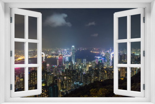 Fototapeta Naklejka Na Ścianę Okno 3D - Hong Kong city skyline timelapse at night with Victoria Harbor and skyscrapers illuminated by lights over water viewed from mountain top.