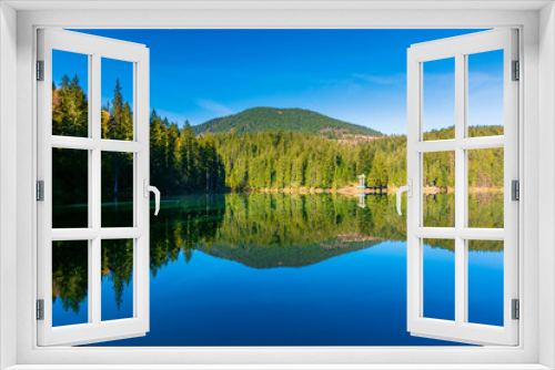 Fototapeta Naklejka Na Ścianę Okno 3D - mountain lake among the coniferous forest. morning nature scenery with reflections in calm water. sunny weather with blue cloudless sky in springtime. location Synevyr national park, ukraine