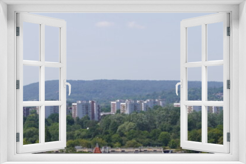 Fototapeta Naklejka Na Ścianę Okno 3D - view of the modern city on the hills, stone buildings. different style houses in the distance. city with lots of greenery, tall trees