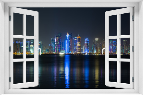Fototapeta Naklejka Na Ścianę Okno 3D - Vibrant Skyline of Doha at Night as seen from the opposite side of the capital city bay at night