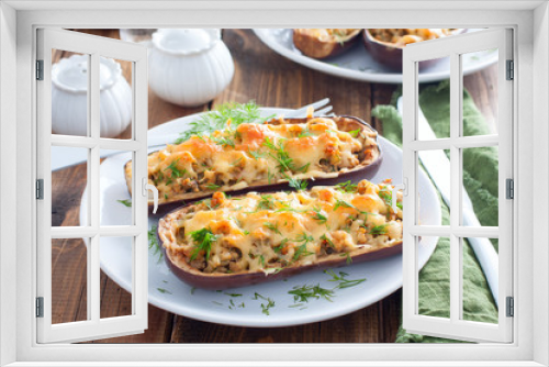 Fototapeta Naklejka Na Ścianę Okno 3D - Baked stuffed eggplant with minced meat with cheese on a white plate on a wooden table, selective focus