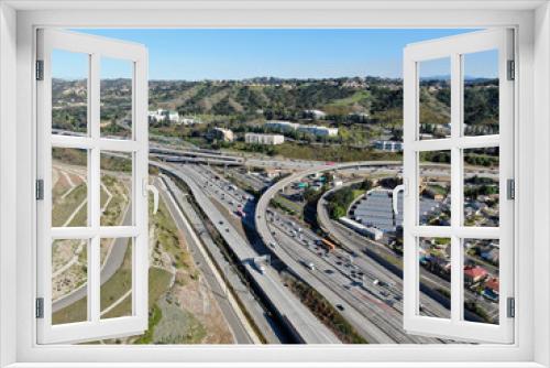 Fototapeta Naklejka Na Ścianę Okno 3D - Aerial view of highway with traffic surrounded by houses in Diamond Bar City. Intersection city transport road with vehicle movement. Eastern Los Angeles, California, USA.