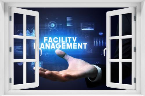 Hand of Businessman holding FACILITY MANAGEMENT inscription, business success concept