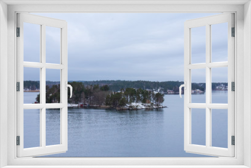 Fototapeta Naklejka Na Ścianę Okno 3D - An island with a few vacation houses near Stockholm, Sweden during a cold and gloomy winter morning.
