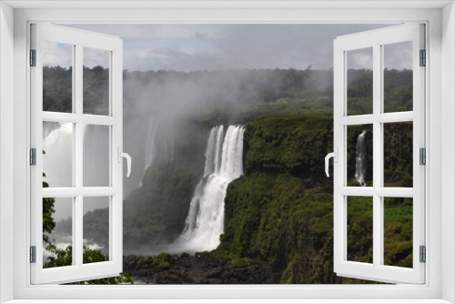 Fototapeta Naklejka Na Ścianę Okno 3D - Iguazu roaring waterfalls against a jungle and gray sky