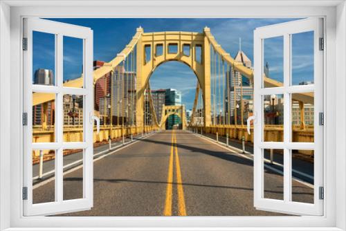 Fototapeta Naklejka Na Ścianę Okno 3D - Traffic and people cross the Allegheny River on the Roberto Clemente Bridge in downtown Pittsburgh Pennsylvania USA