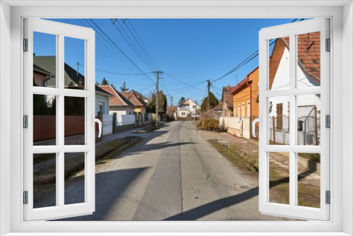 Fototapeta Naklejka Na Ścianę Okno 3D - Village street with houses, generic view in Ecser, Hungary