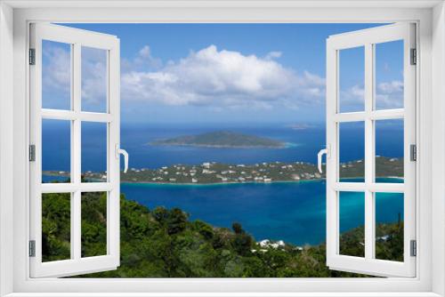 Fototapeta Naklejka Na Ścianę Okno 3D - Panoramic view of a small bay on a remote Caribbean island with lush trees , aqua water and a blue sky with white clouds.