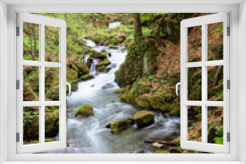 Fototapeta Naklejka Na Ścianę Okno 3D - rapid water stream in the forest. powerful flow among the mossy rocks. beautiful nature scenery in spring. vivid green foliage on the trees