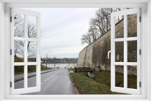 Fototapeta Naklejka Na Ścianę Okno 3D - Road to river Narva embankment with old bastion on the side