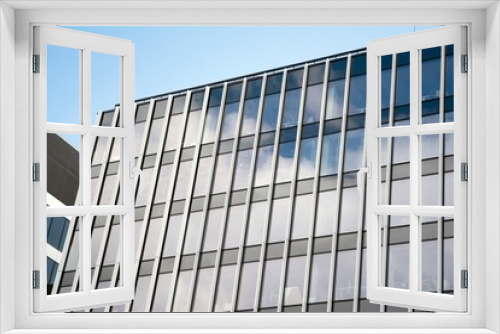Fototapeta Naklejka Na Ścianę Okno 3D - Modern curtain wall made of glass and steel. Blue sky and clouds reflected in windows of modern office building. 