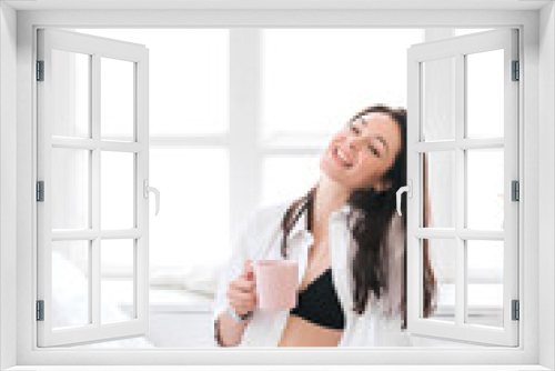 Positive woman drinking her coffee in bed.