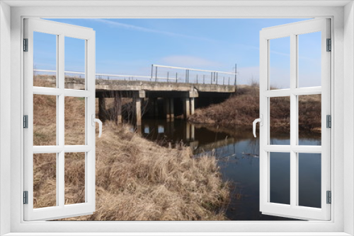 Fototapeta Naklejka Na Ścianę Okno 3D -  bridge over a small river against a blue sky