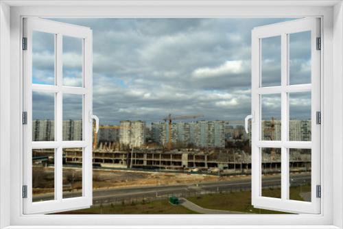 Fototapeta Naklejka Na Ścianę Okno 3D - aerial view of a residential area of ​​the city with gray volumetric clouds and a construction site
