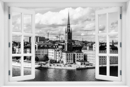 Fototapeta Naklejka Na Ścianę Okno 3D - Black and white city landscape of the old town, Gamla Stan island and the city hall on the waterfront of Lake Malaren as seen from Monteliusvagen hill with dramatic clouded sky in Stockholm, Sweden