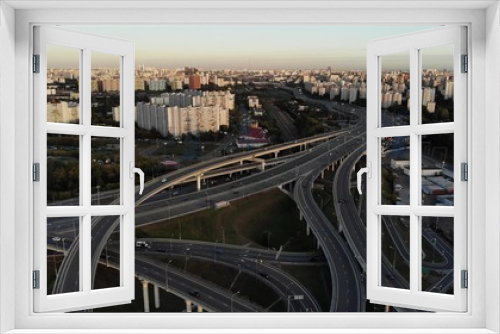 Fototapeta Naklejka Na Ścianę Okno 3D - Aerial drone view of highway multi-level junction road with moving cars at sunset. Cars are moving on a multi-level road junction