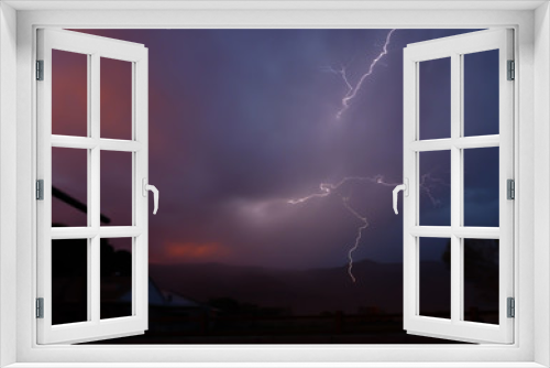 Fototapeta Naklejka Na Ścianę Okno 3D - Lightning emanates in all directions from stormy sunset sky