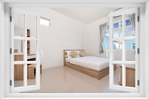 Wooden bed and dressing table in bedroom of house, villa, apartment and condo with a window