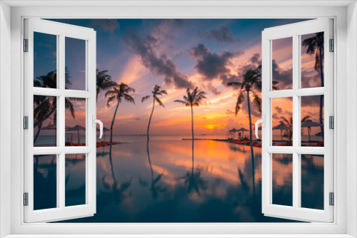 Fototapeta Naklejka Na Ścianę Okno 3D - Beautiful poolside and sunset sky with palm trees silhouette. Luxurious tropical beach landscape, deck chairs and loungers and water reflection. Tranquil summer vacation, travel concept infinity pool