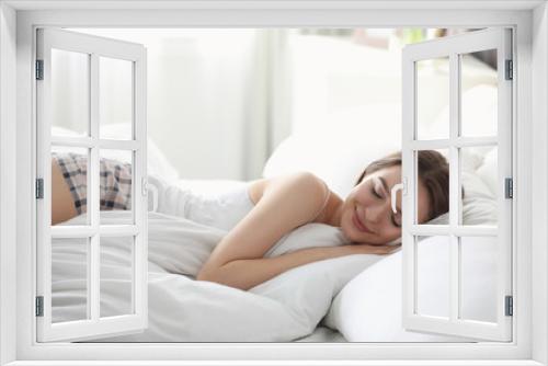 Young woman sleeping on comfortable pillow in bed at home