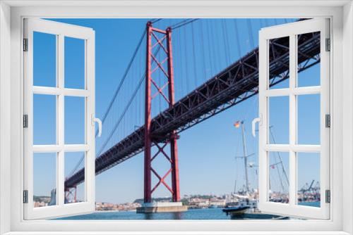 Fototapeta Naklejka Na Ścianę Okno 3D - sailing yacht passing the Bridge of the 25 th of April, over the river Tejo in Lisbon, Portugal