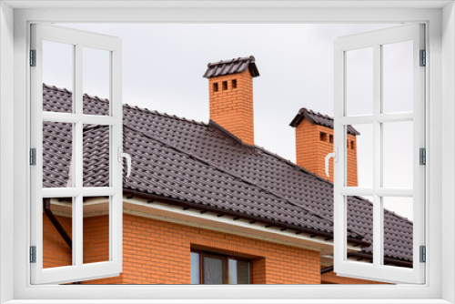 Fototapeta Naklejka Na Ścianę Okno 3D - a brown rooftop of a ceramic tile with a pipe a storm drainage system, close up details of the architectural structure of brick house.