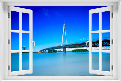 Fototapeta Naklejka Na Ścianę Okno 3D - A modern bridge connecting two islands with pastel blue skies