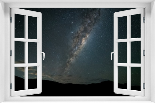 Fototapeta Naklejka Na Ścianę Okno 3D - A night time photo of the Milky Way galaxy rising above mountains against a dark starry sky in the southern hemisphere of Australia