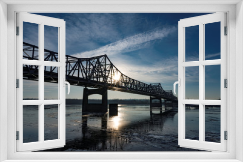 Fototapeta Naklejka Na Ścianę Okno 3D - Bridge over Icy river at dawn with cloudscape