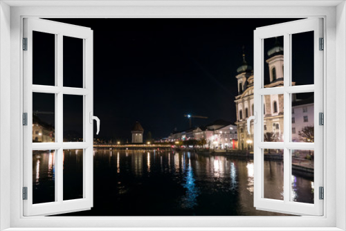 Illuminated Lucerne and Chapel Bridge reflect on the river