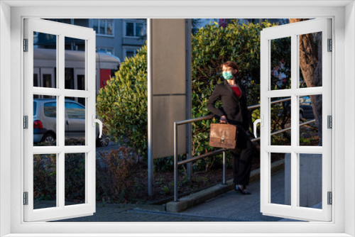 Businessfrau mit Atemmaske und Aktentasche