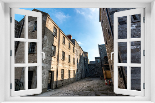 Fototapeta Naklejka Na Ścianę Okno 3D - A historic old Prison architecture building in Ireland with rooms, doors, windows with blue sky.