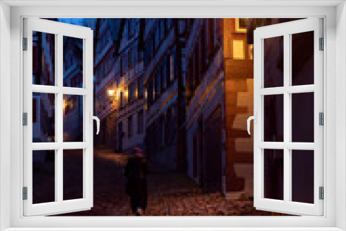 Fototapeta Naklejka Na Ścianę Okno 3D - calle en cuesta por la noche navideña con persona paseando solitariamente