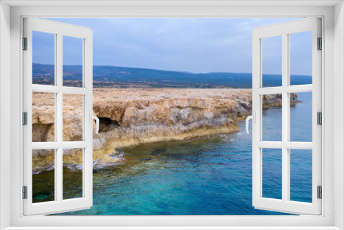 Fototapeta Naklejka Na Ścianę Okno 3D - Landscape. View from the sea to Cyprus rocky coast. Rocks with gorges and faults. Mountains in the background. Near Lara beach