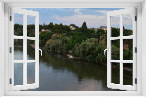 Fototapeta Naklejka Na Ścianę Okno 3D - The green bank of the Danube River with several houses above the river