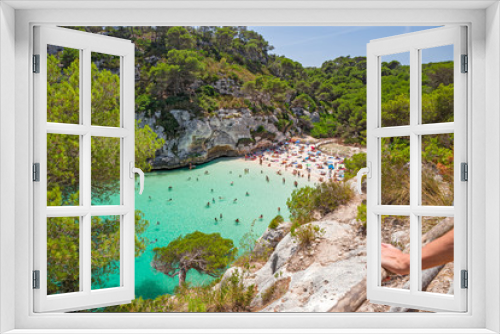 Fototapeta Naklejka Na Ścianę Okno 3D - Bathers refresh themselves in the fresh and transparent waters of a bay on the island of Menorca in Spain.