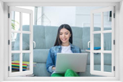 Young woman in green pants sitting on the floor and studying