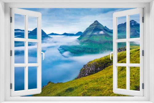 Fototapeta Naklejka Na Ścianę Okno 3D - Dramatic morning view of Faroe Islands with low clouds, Denmark, Europe with low clouds. Adorable summer scene of Eysturoy island, Funningur village location. Beauty of nature concept background.