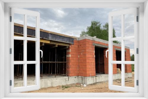 Fototapeta Naklejka Na Ścianę Okno 3D - Close up of unfinished house in residential area. Modern architecture of construction brick house for comfortable stay of people.