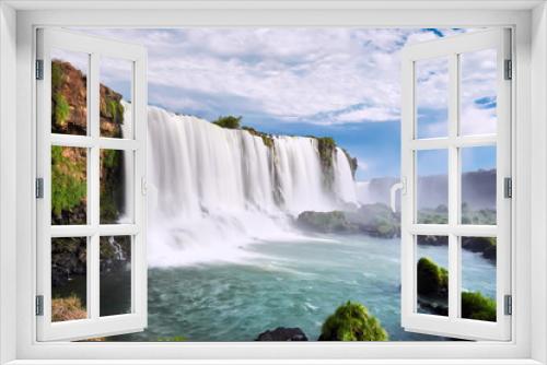 Fototapeta Naklejka Na Ścianę Okno 3D - Iguazu waterfalls in Argentina, view from Devil's Mouth. Panoramic view of many majestic powerful water cascades with mist. Panoramic image with blue sky and clouds.
