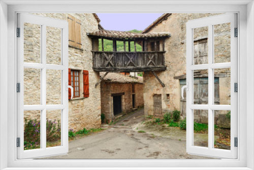Fototapeta Naklejka Na Ścianę Okno 3D - Vieilles maisons de village reliées par une passerelle en bois en Occitanie, France