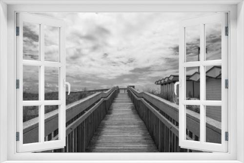 Fototapeta Naklejka Na Ścianę Okno 3D - Outdoor wooden boardwalk walkway, with sky and cloud background.  Beach cabana pier plank bridge.