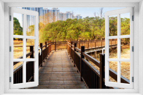 Fototapeta Naklejka Na Ścianę Okno 3D - Wooden bridge over little river in city park