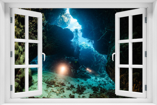 Fototapeta Naklejka Na Ścianę Okno 3D - typical underwater cave in a red sea reef with an underwater photographer diver