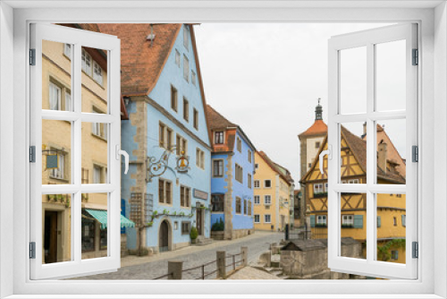 Fototapeta Naklejka Na Ścianę Okno 3D - Ein sehr berühmtes Motiv von Rothenburg ob der Tauber ist das Fachwerkhaus Plönlein. Es ist von Türmen und mittelalterlichen Häusern umgeben. Touristen aus der ganzen Welt kommen in die Stadt.