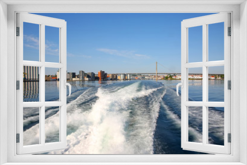 Fototapeta Naklejka Na Ścianę Okno 3D - Waves in the ocean from a wake of a boat while sailing away from Stavanger harbour. City Bridge & port in the background, Stavanger, Rogaland county, Norway.