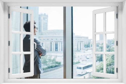 Serious businessman standing near window