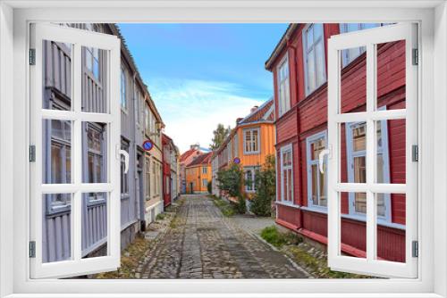 Fototapeta Naklejka Na Ścianę Okno 3D - A picturesque street with colorful wooden houses in Bakklandet district. Old neighbourhood in Trondheim, with small wooden houses and narrow streets.