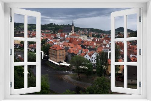 Fototapeta Naklejka Na Ścianę Okno 3D - Panorama of tiled roofs of buildings of the historic part of Cesky Krumlov. View of the ancient bridge over the Vltava, the embankment and St. Vitus Church.